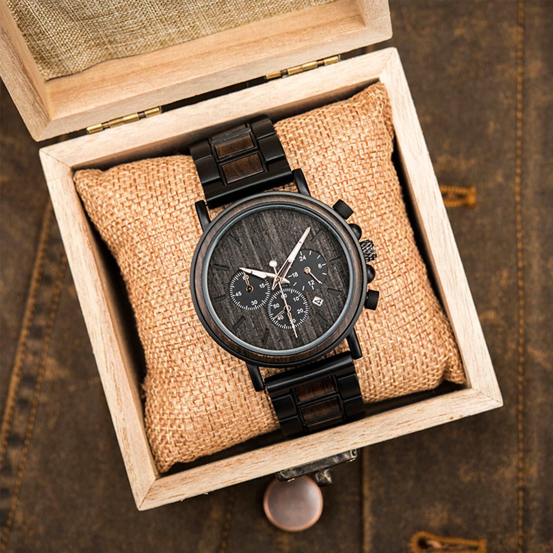 A black metal and ebony men wooden watch packed up with square wooden box