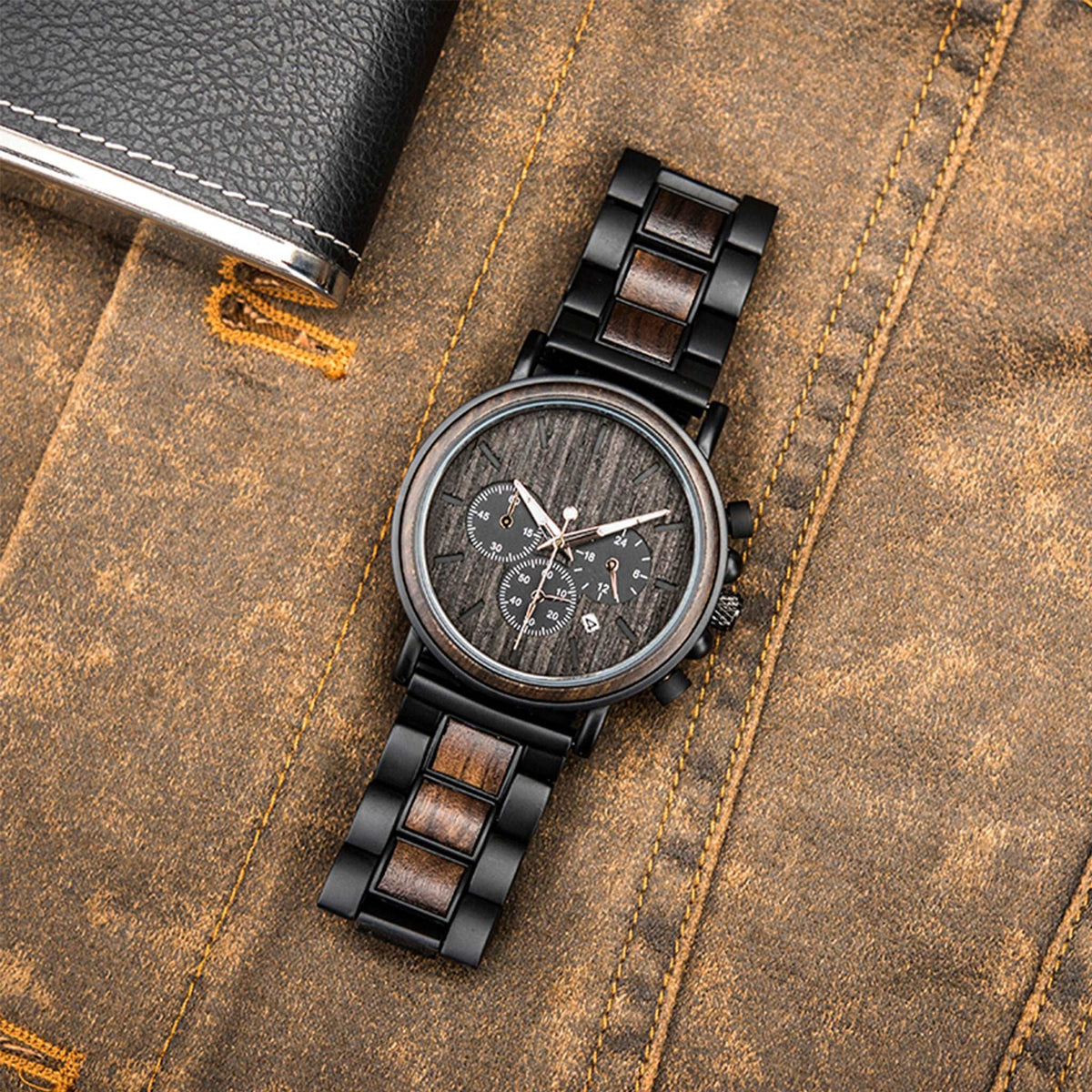 Black metal and ebony men watch with black face lying on the jean