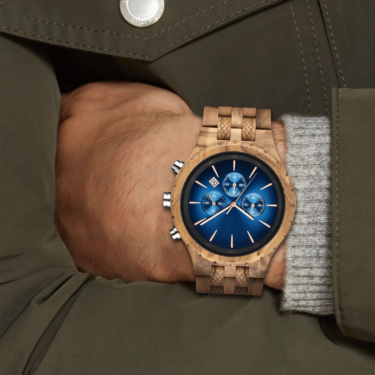 A man wearing an olive wooden watch with blue face
